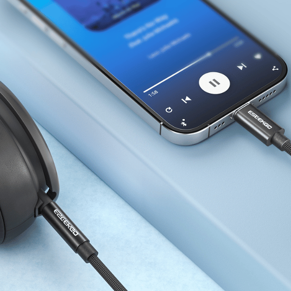 Braided 3.5mm audio cable connecting a phone playing music to headphones