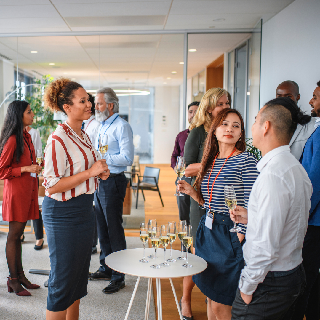 Colleagues chatting with drinks at an office social event