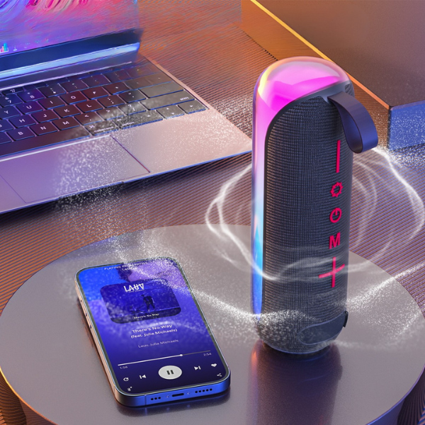 Eseekgo portable speaker with pink and blue lights beside a phone playing music and a laptop